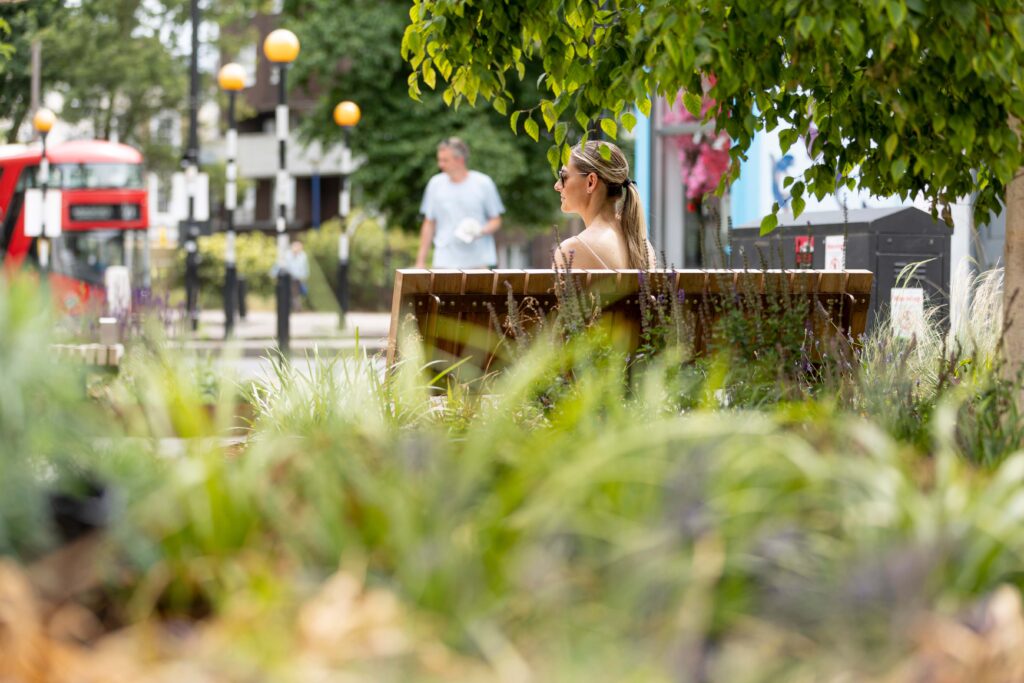Woman sitting on AKRI planter with timber seating