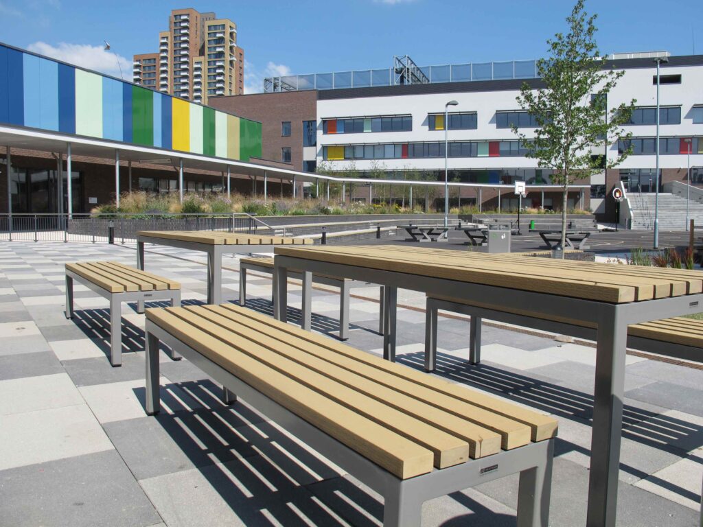 a set of parallel picnic tabnles and benches in Bow School