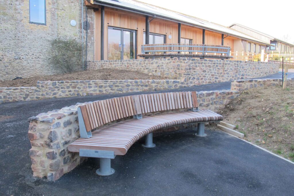 Railroad bench with backrest outside The Donkey Sanctuary in Sidmouth